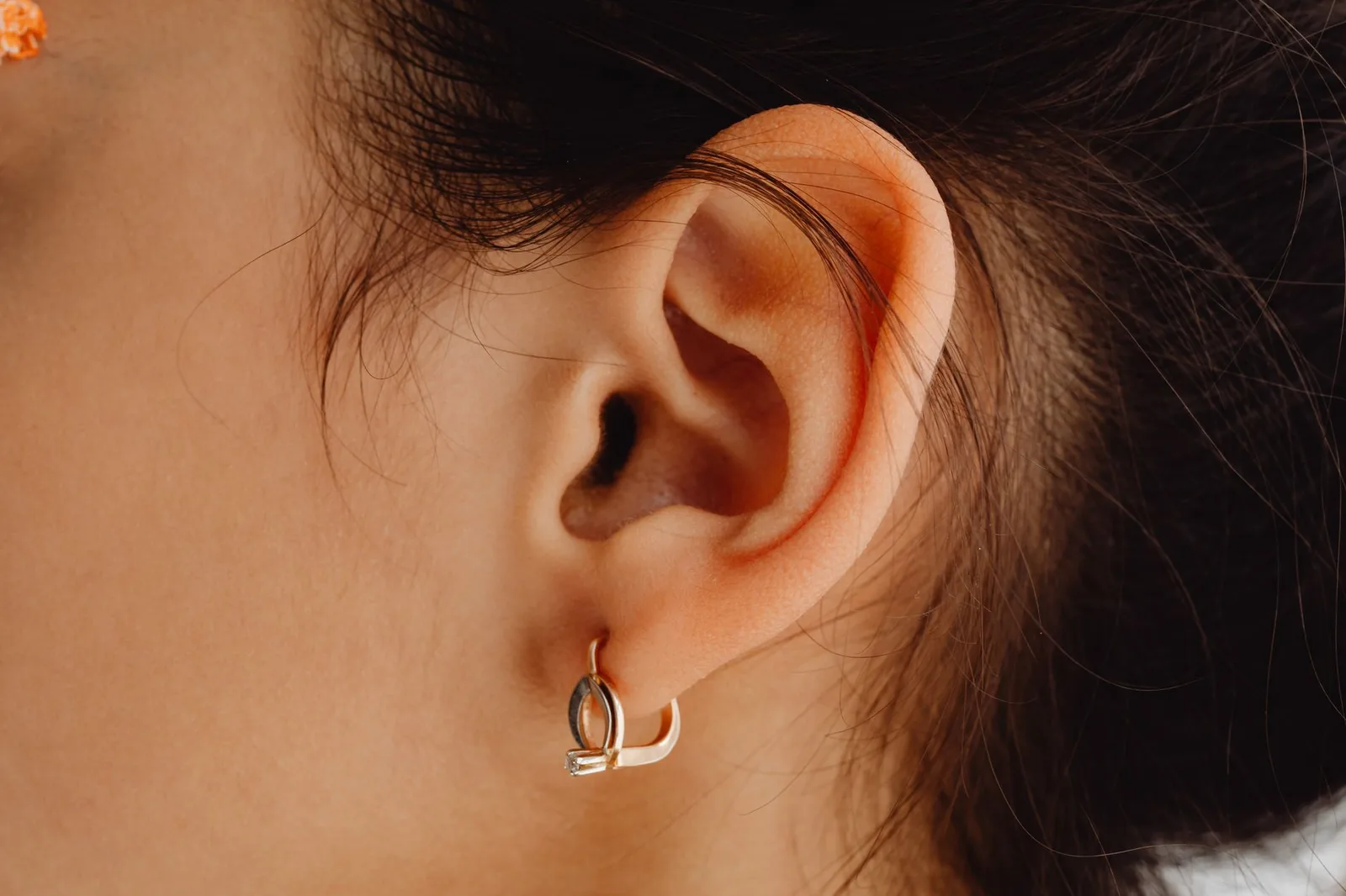 Detailed close-up of a woman's ear adorned with a stylish earring.